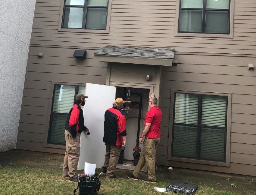 Three 5th Street Services techs at a water heater closet
